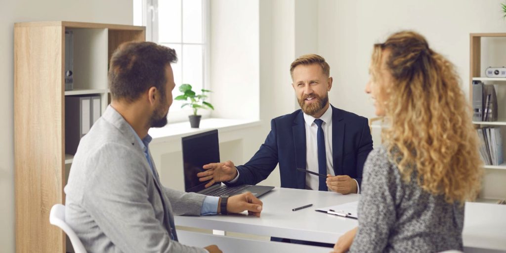 Agent za nekretnine u razgovoru sa klijentima u kancelariji